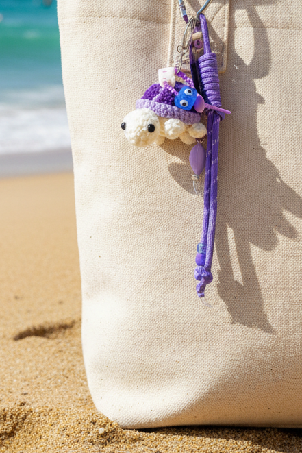 Porte-clés tortue violette au crochet gros plan sur sac beige plage - accessoire bohème chic Joyas by Jo
