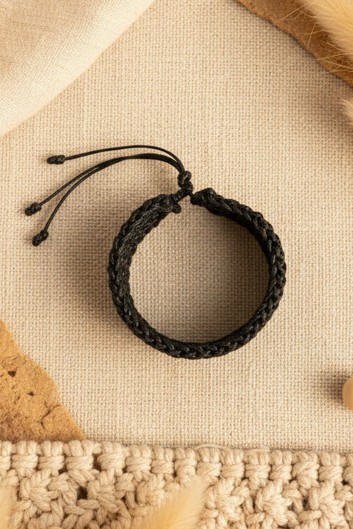 Bracelet noir tressé Joyas by Jo présenté à plat sur un fond neutre mettant en valeur sa forme circulaire.