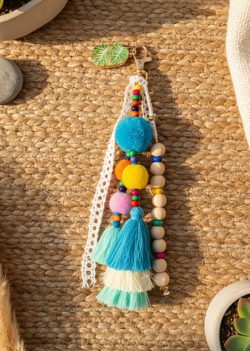 Détail du bijou de sac Riviera - pompons laine, perles bois et glands colorés
