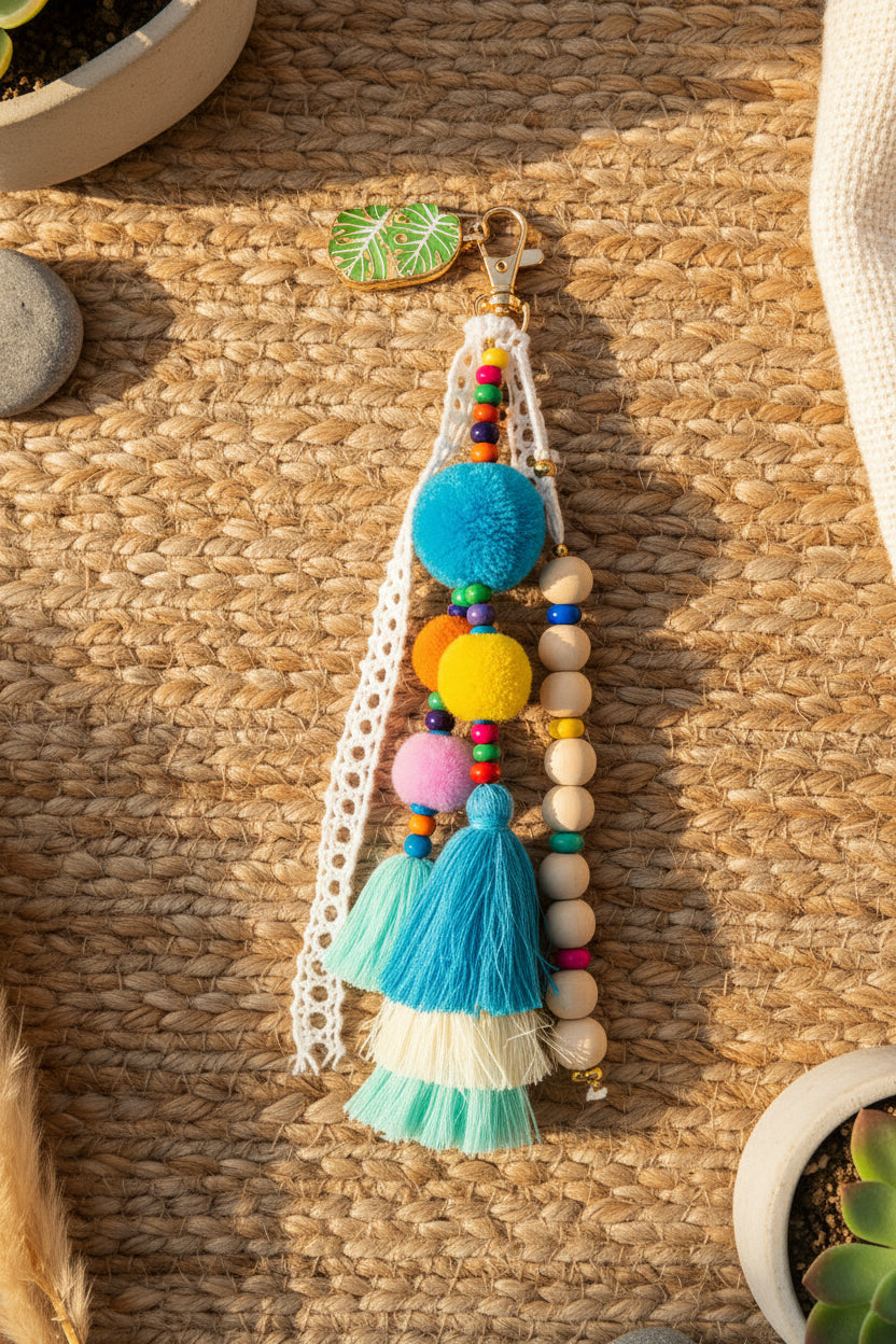 Détail du bijou de sac Riviera - pompons laine, perles bois et glands colorés
