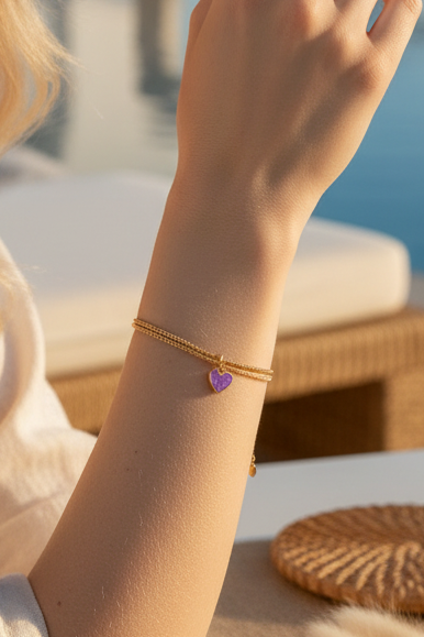 Bracelet doré avec charm coeur violet porté au poignet - bijou bohème chic Joyas by Jo
