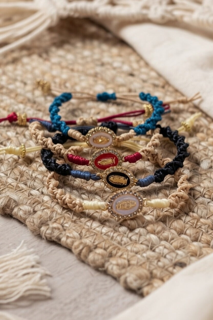 Sélection de bracelets artisanaux
Joyas by Jo en macramé tressé avec médaillons ovales sertis de cristaux. Couleurs disponibles :
bleu pétrole, rouge, noir et beige, présentés sur un tapis en jute naturelle et macramé bohème.
