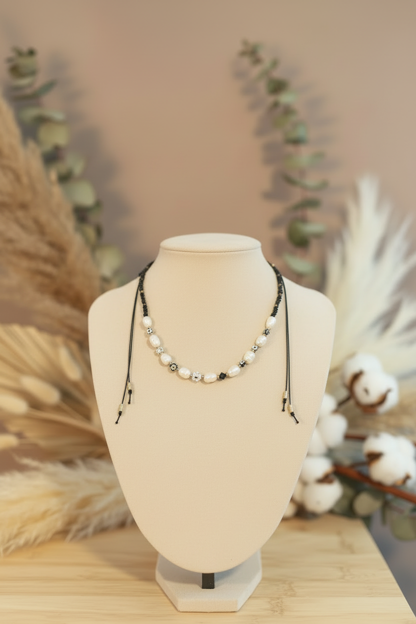 Collier Joyas by Jo avec perles de culture blanches et perles fleurs noires sur buste beige