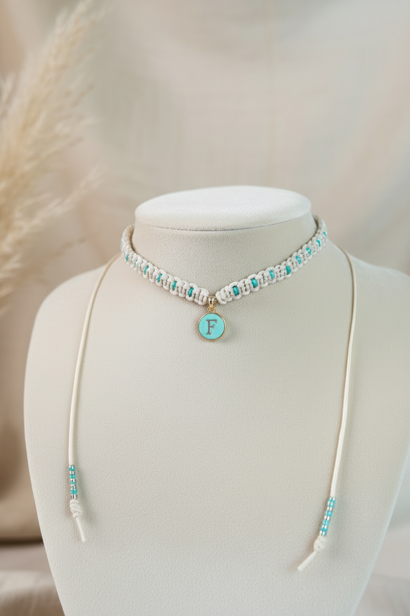 Collier ras de cou en macramé beige avec perles turquoise et pendentif initiale F de Joyas by Jo.