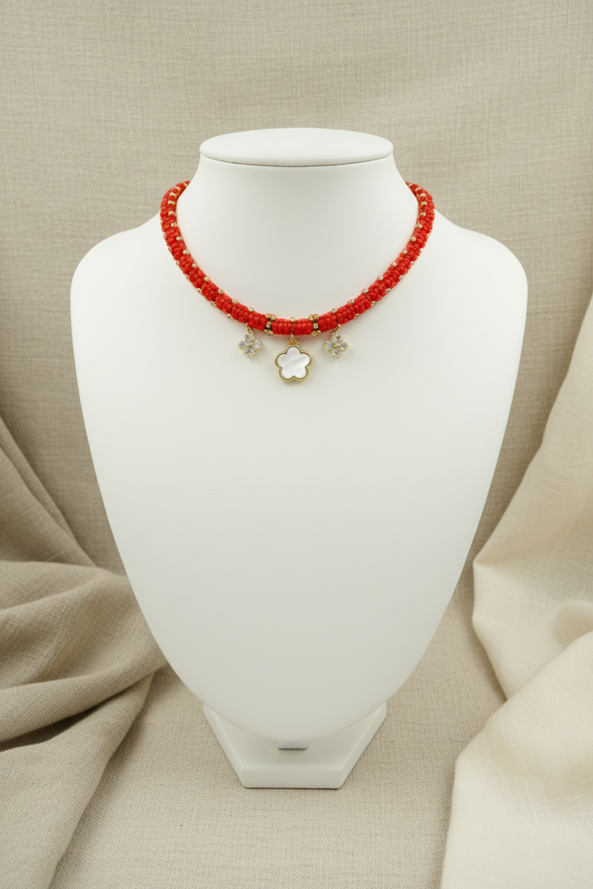 Collier ras de cou Joyas by Jo en cordon tressé rouge avec trèfle en nacre blanche et charms sertis.