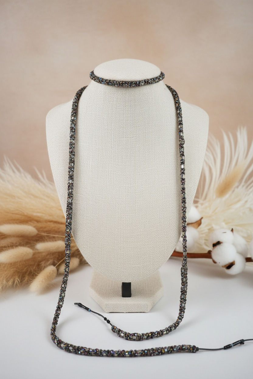 Collier sautoir long Joyas by Jo en perles fines irisées aux reflets métalliques, présenté sur un buste beige. La maille serrée et artisanale souligne la précision du travail de perlage pour un bijou polyvalent et raffiné.