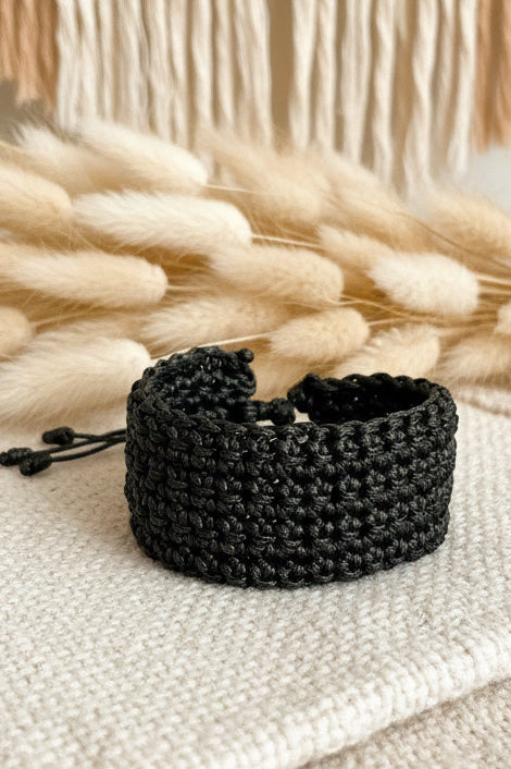Gros plan sur les détails du tressage serré d'un bracelet noir Joyas by Jo.