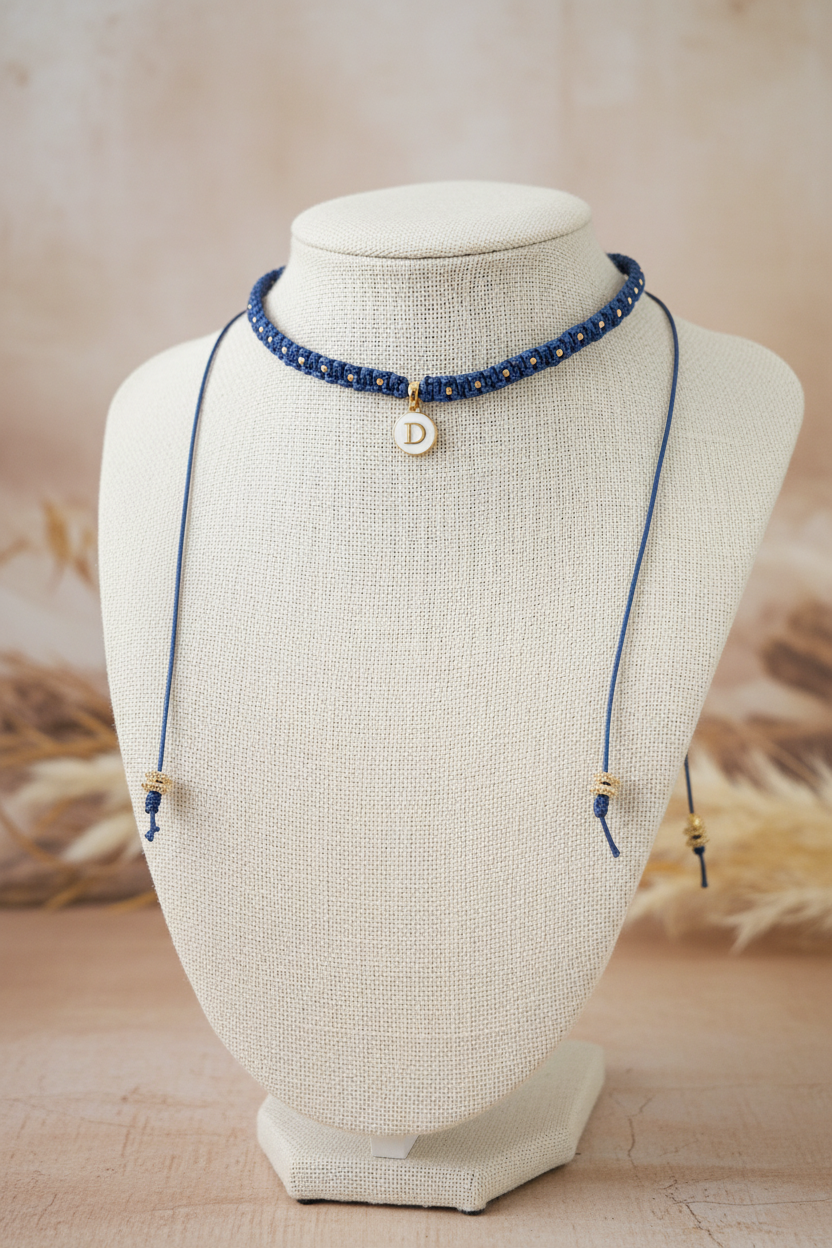 Collier choker Joyas by Jo en macrame bleu avec medaille initiale D et details dore sur buste d'exposition.
